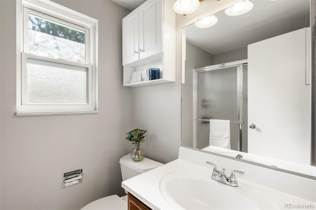 full bathroom featuring a stall shower, toilet, and vanity