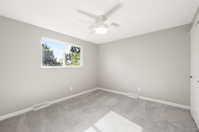 spare room featuring ceiling fan, carpet, and baseboards