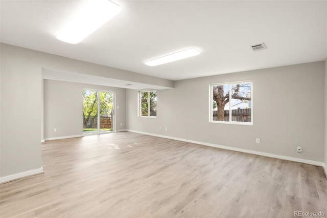 spare room with baseboards and light wood-style flooring
