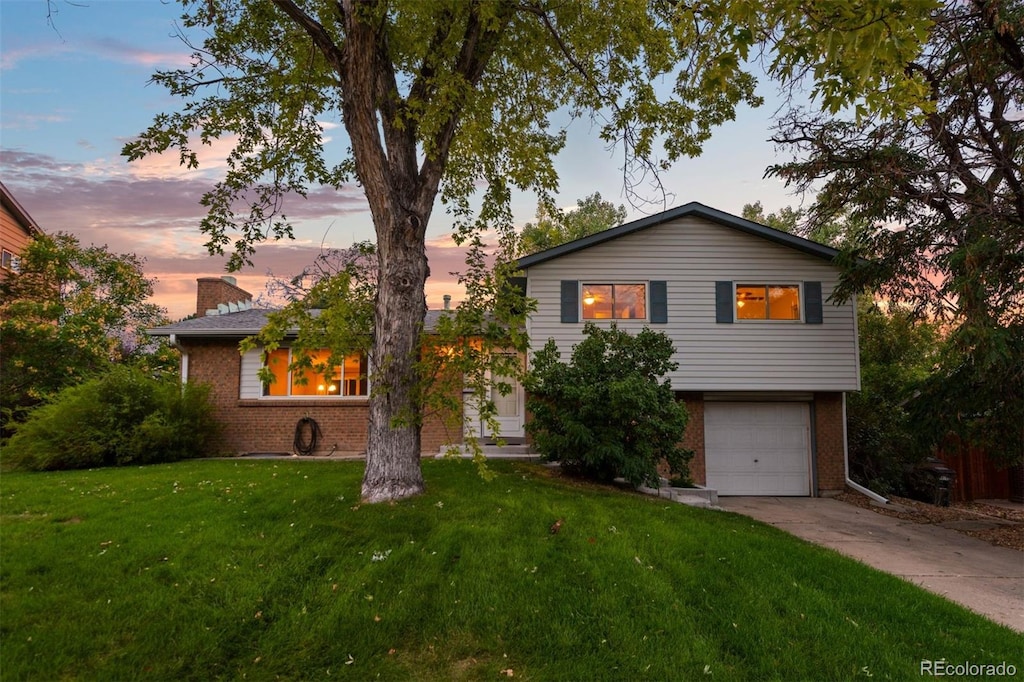 split level home with a yard and a garage