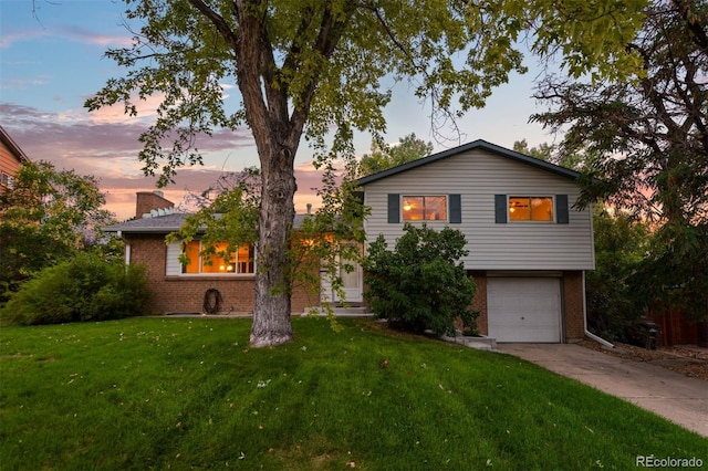 split level home with a yard and a garage