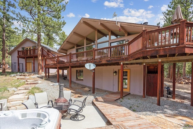 back of house with a wooden deck and a patio area