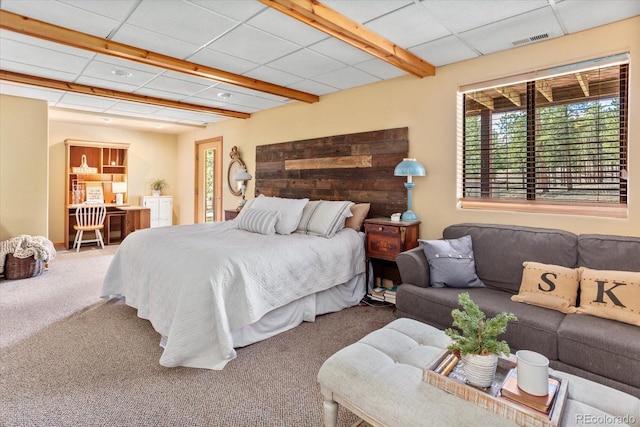 bedroom with a paneled ceiling, visible vents, and carpet