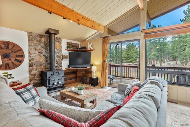 carpeted living area featuring a wood stove and lofted ceiling with beams