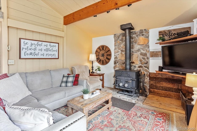living room with lofted ceiling with beams and a wood stove
