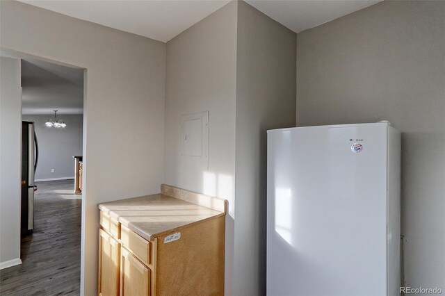 kitchen with stainless steel refrigerator, a chandelier, dark hardwood / wood-style floors, and white refrigerator