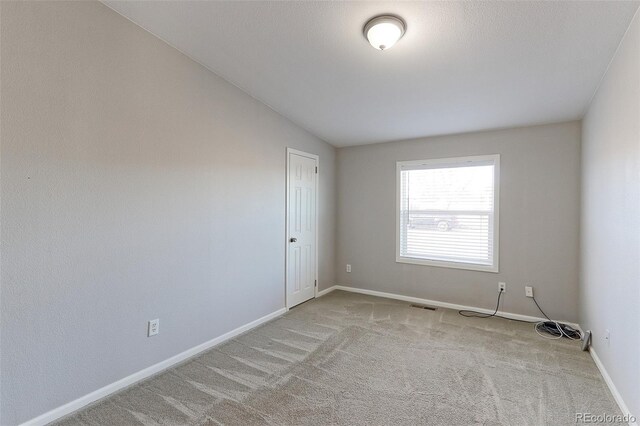 carpeted spare room featuring lofted ceiling