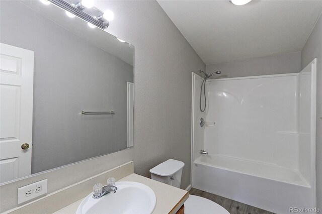 full bathroom featuring wood-type flooring, vanity, toilet, and shower / washtub combination