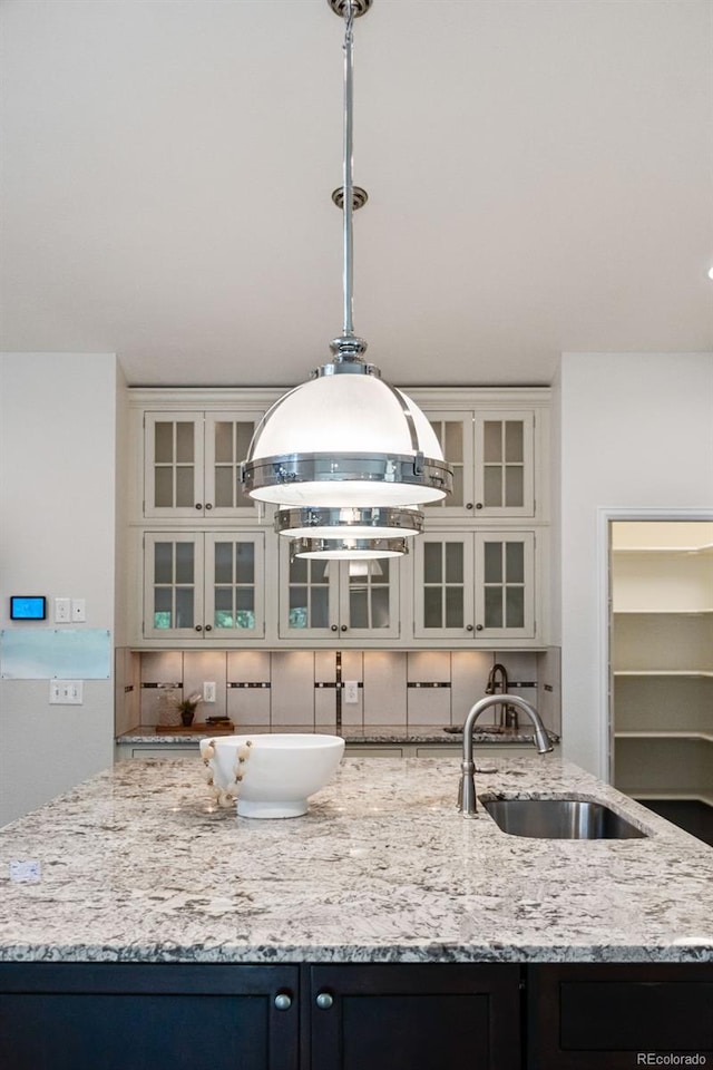 5980 Dunraven Ct, Golden, CO 80403 - kitchen with light stone counters, hanging light fixtures, and white cabinetry