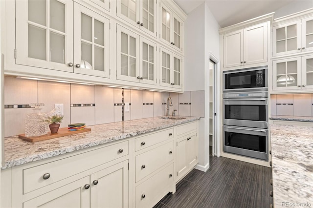 5980 Dunraven Ct, Golden, CO 80403 - kitchen featuring black microwave, stainless steel double oven, tasteful backsplash, and light stone counters