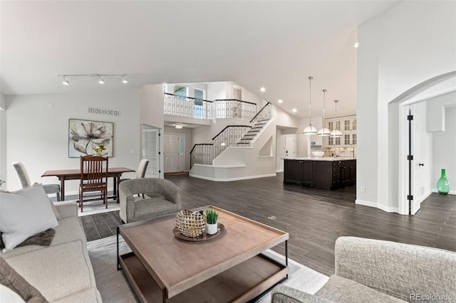 5980 Dunraven Ct, Golden, CO 80403 - living area featuring stairs, high vaulted ceiling, dark wood-type flooring, and arched walkways