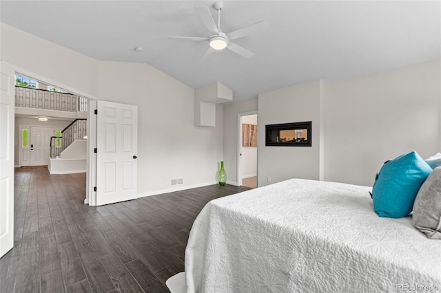 5980 Dunraven Ct, Golden, CO 80403 - bedroom featuring dark wood-type flooring, lofted ceiling, ceiling fan, and a multi sided fireplace