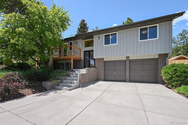 1073 Xenon St, Golden, CO 80401 - split foyer home with brick siding, a garage, concrete driveway, and board and batten siding