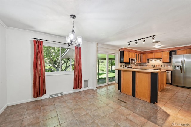1073 Xenon St, Golden, CO 80401 - kitchen with appliances with stainless steel finishes, light countertops, healthy amount of natural light, a chandelier, and crown molding