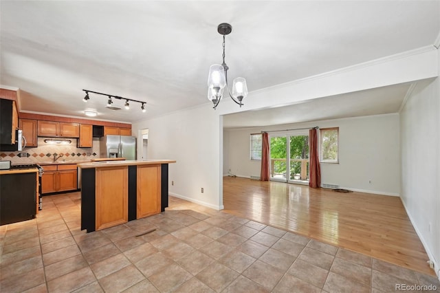 1073 Xenon St, Golden, CO 80401 - kitchen featuring appliances with stainless steel finishes, open floor plan, ornamental molding, a kitchen island, and a chandelier