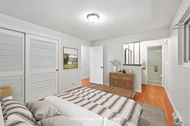 1073 Xenon St, Golden, CO 80401 - bedroom featuring a closet, light wood-style floors, baseboards, and connected bathroom