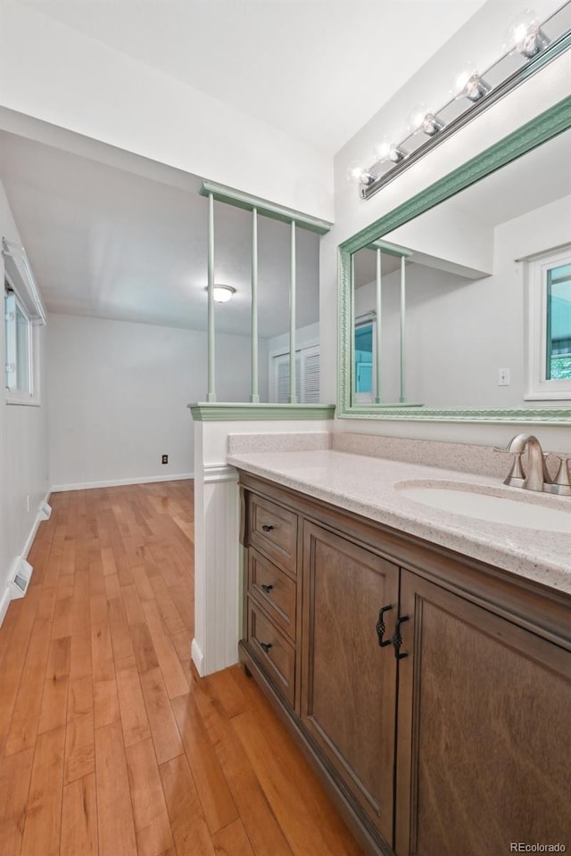 1073 Xenon St, Golden, CO 80401 - bathroom featuring vanity, wood finished floors, baseboards, and plenty of natural light
