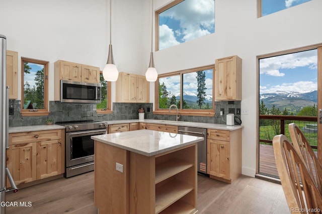452 Gcr 835, Fraser, CO 80442 - kitchen with stainless steel appliances, light brown cabinets, a high ceiling, light wood-type flooring, and decorative backsplash