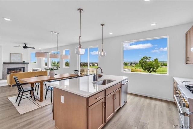 900 Eldorado Ln, Louisville, CO 80027 - kitchen with appliances with stainless steel finishes, light wood finished floors, a glass covered fireplace, light countertops, and recessed lighting