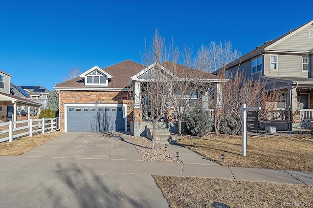 view of front of property featuring stone siding, concrete driveway, fence, and an attached garage