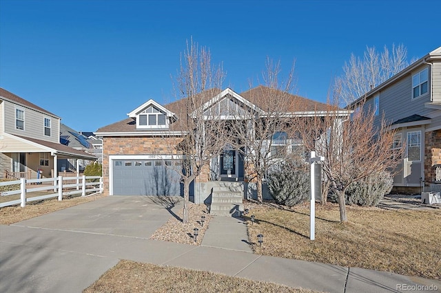 view of front of property featuring a garage, concrete driveway, and fence