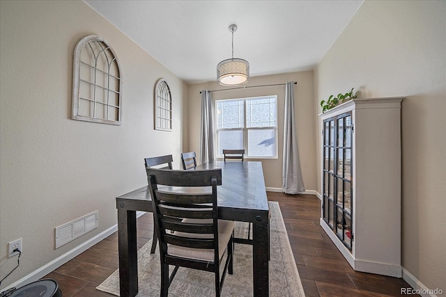 dining room featuring dark wood-style flooring, visible vents, and baseboards