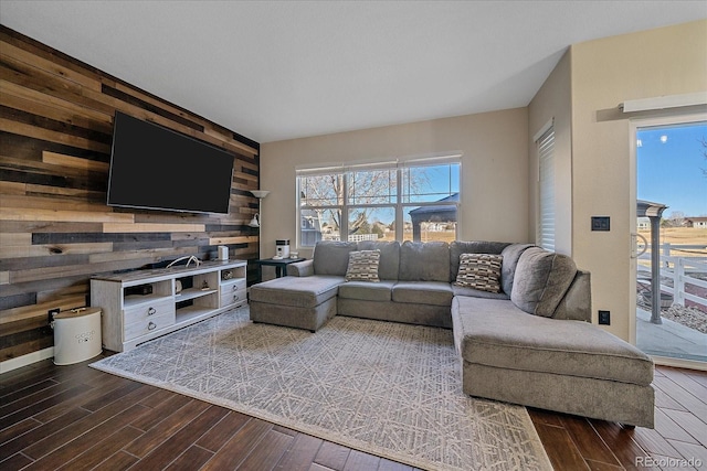 living room featuring wood walls, an accent wall, and dark wood-style floors