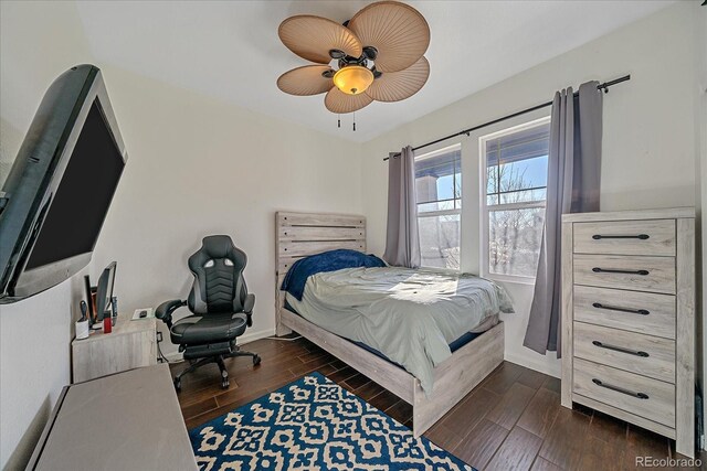 bedroom with ceiling fan, baseboards, and wood finish floors