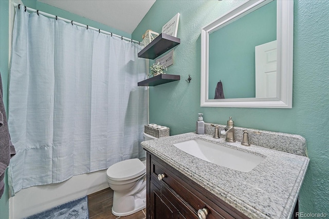 bathroom featuring a textured wall, toilet, wood finished floors, shower / bath combination with curtain, and vanity