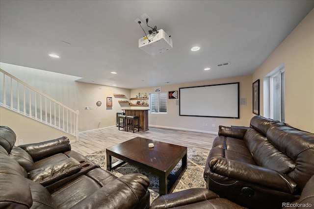 home theater room featuring recessed lighting, wood finished floors, visible vents, baseboards, and a dry bar