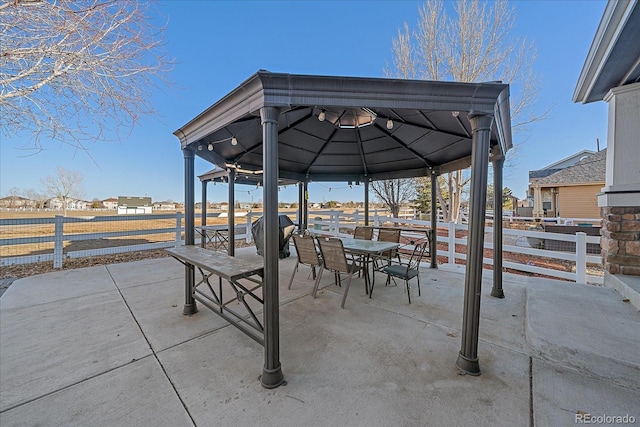 view of patio / terrace featuring a gazebo, outdoor dining space, and fence