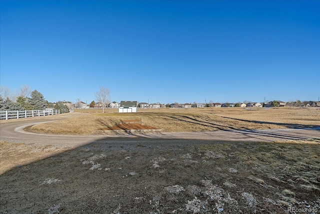 view of yard featuring a rural view and fence