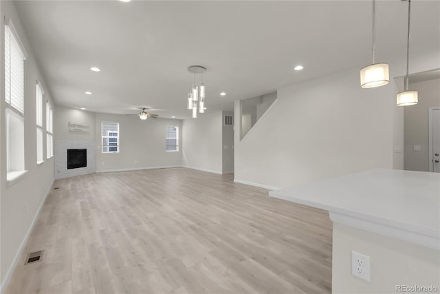 23895 E Rocky Top Pl, Aurora, CO 80016 - unfurnished living room with a ceiling fan, light wood-style floors, recessed lighting, a fireplace, and baseboards