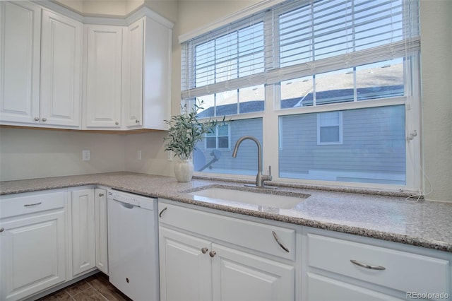 kitchen featuring light stone counters, dishwasher, sink, and white cabinets