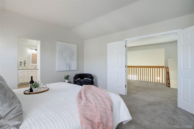 bedroom with light colored carpet, ensuite bathroom, and vaulted ceiling