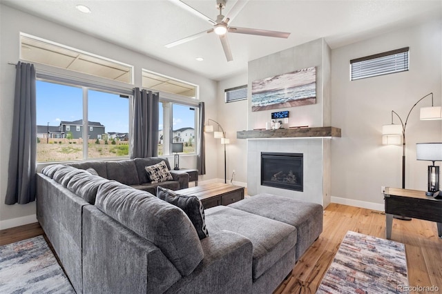 23814 E 36th Pl, Aurora, CO 80019 - living area with light wood-style flooring, a tiled fireplace, ceiling fan, recessed lighting, and plenty of natural light