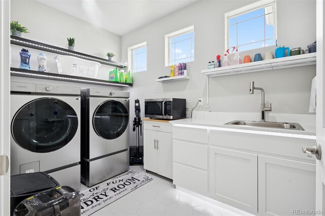 23814 E 36th Pl, Aurora, CO 80019 - laundry area featuring washing machine and clothes dryer, light tile patterned flooring, and cabinet space
