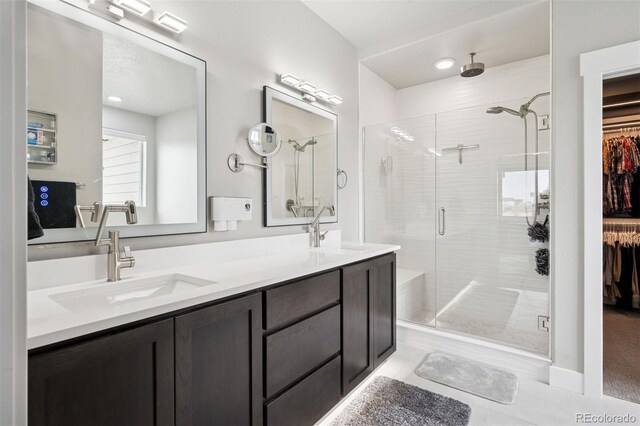 23814 E 36th Pl, Aurora, CO 80019 - full bathroom with a shower stall, double vanity, a walk in closet, and tile patterned floors