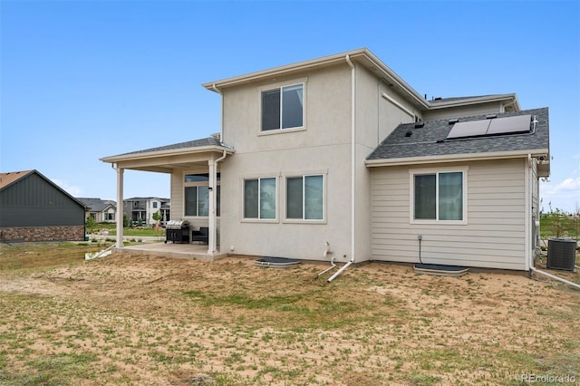 23814 E 36th Pl, Aurora, CO 80019 - back of house featuring a patio area, solar panels, a lawn, stucco siding, and a shingled roof