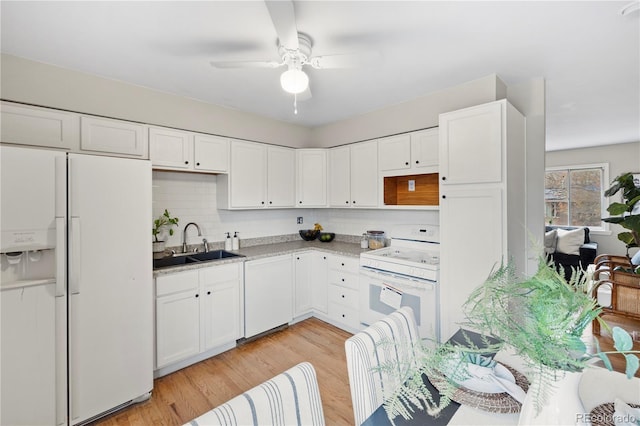 kitchen with a sink, light wood-type flooring, white appliances, and white cabinetry