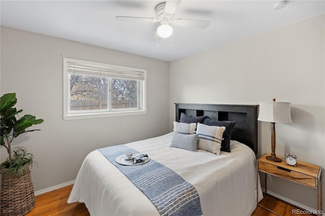 bedroom featuring wood finished floors, baseboards, and ceiling fan