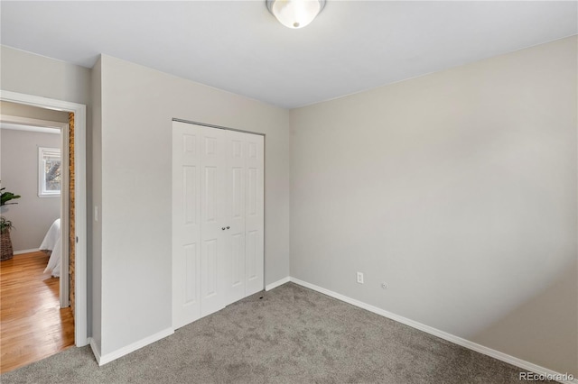 unfurnished bedroom featuring carpet, a closet, and baseboards