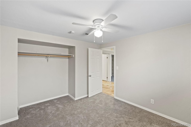 unfurnished bedroom with visible vents, a closet, carpet flooring, baseboards, and ceiling fan