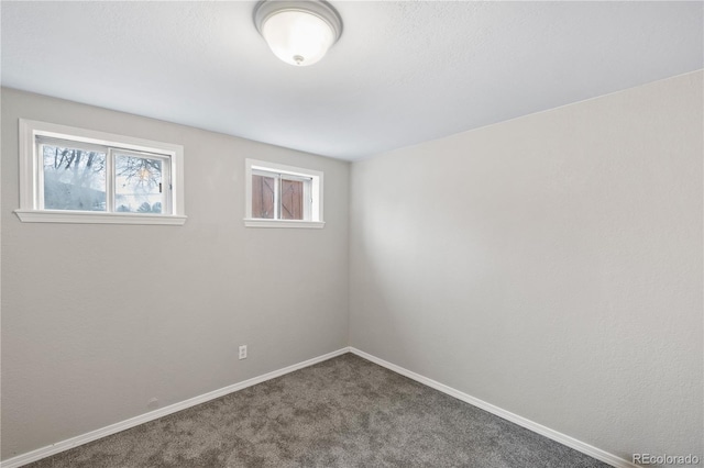 empty room featuring baseboards and carpet flooring