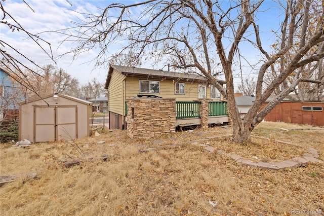 rear view of property with a detached garage, an outbuilding, and a shed