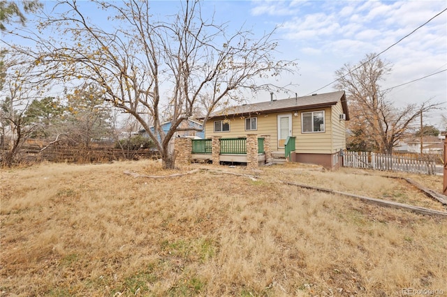 rear view of house with a deck and fence