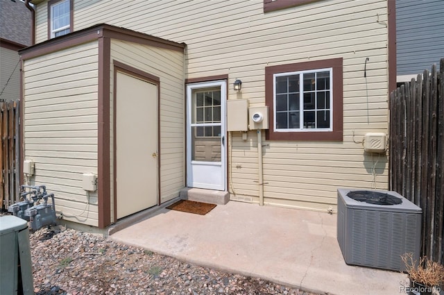 entrance to property featuring central AC, a patio area, and fence