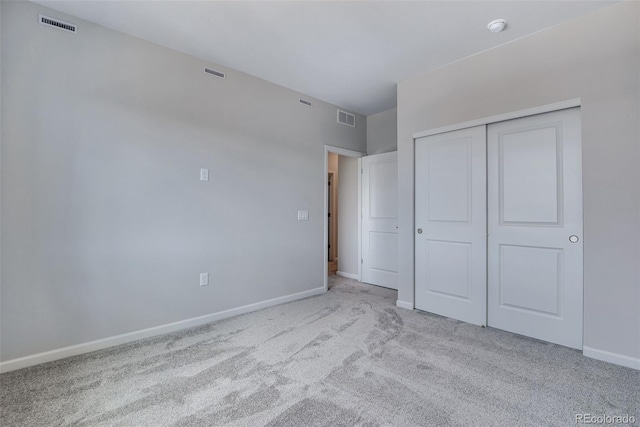 unfurnished bedroom featuring a closet and light colored carpet