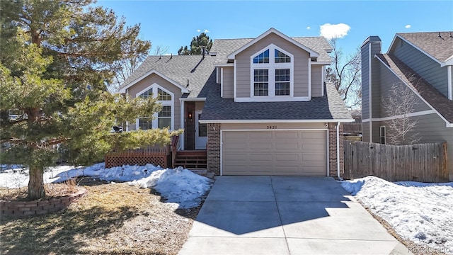 view of front of home featuring brick siding, a shingled roof, concrete driveway, an attached garage, and fence