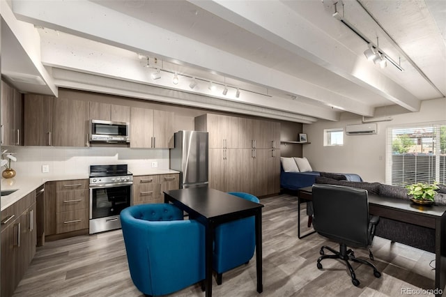1495 Vrain St Unit 110, Denver, CO 80204 - home office featuring track lighting, light wood-style flooring, a wall mounted air conditioner, and beam ceiling